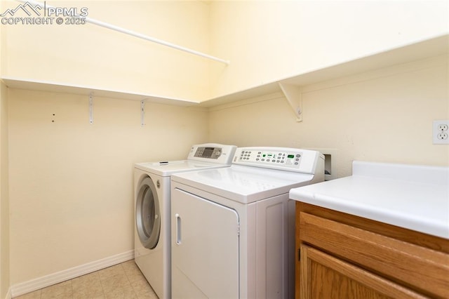 laundry area featuring baseboards, separate washer and dryer, and cabinet space