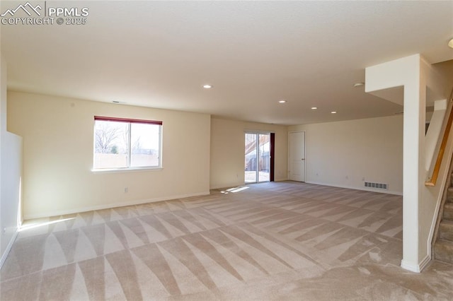 unfurnished room with stairs, visible vents, a wealth of natural light, and light carpet