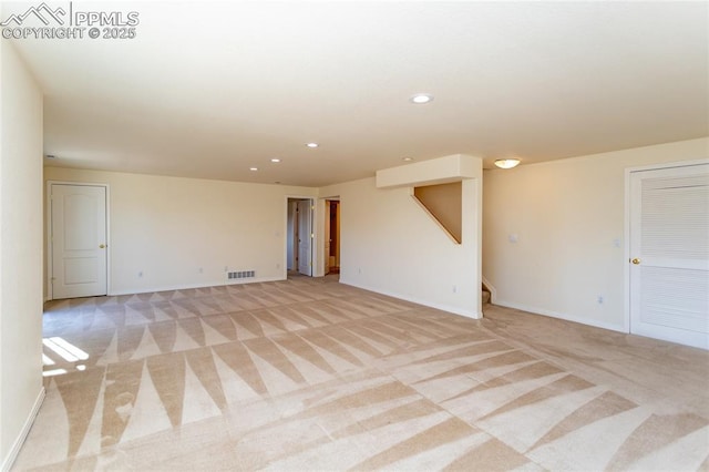 spare room with visible vents, recessed lighting, stairway, baseboards, and light colored carpet