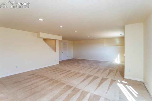 empty room featuring recessed lighting, baseboards, and light colored carpet