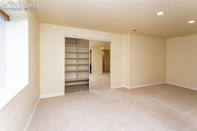 carpeted spare room featuring recessed lighting, visible vents, and baseboards