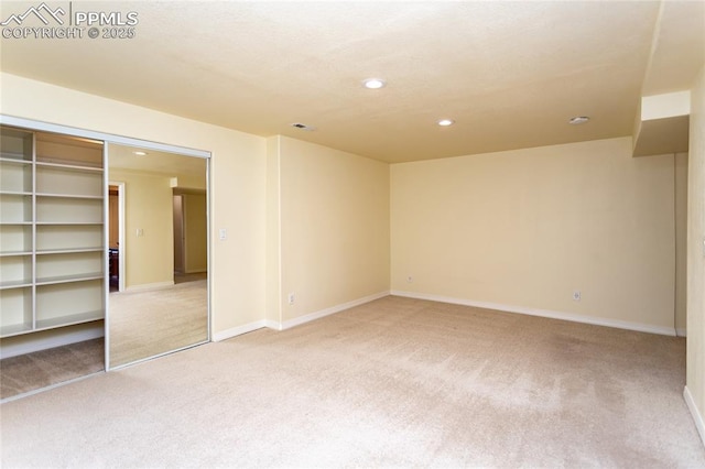 empty room featuring light carpet, visible vents, recessed lighting, and baseboards