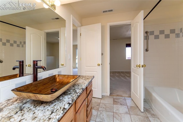 bathroom featuring shower / bathing tub combination, visible vents, baseboards, and vanity