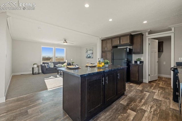 kitchen with ornamental molding, dark wood-style flooring, a kitchen island, and baseboards