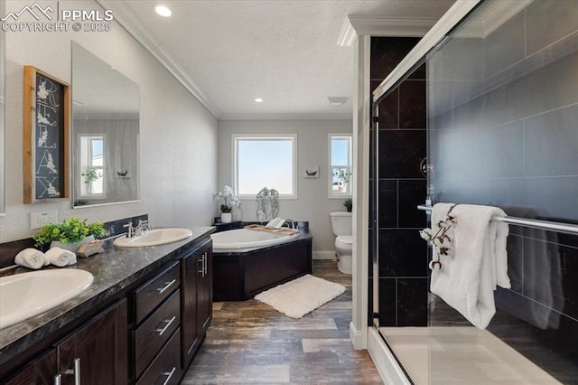 full bath with wood finished floors, ornamental molding, tiled shower, and a sink