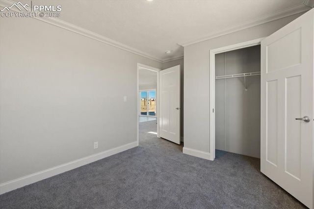 unfurnished bedroom with ornamental molding, a closet, dark carpet, and baseboards