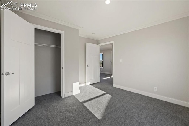 unfurnished bedroom with baseboards, dark colored carpet, a closet, and crown molding