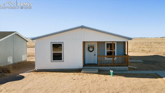 view of front of house with a porch and an outdoor structure