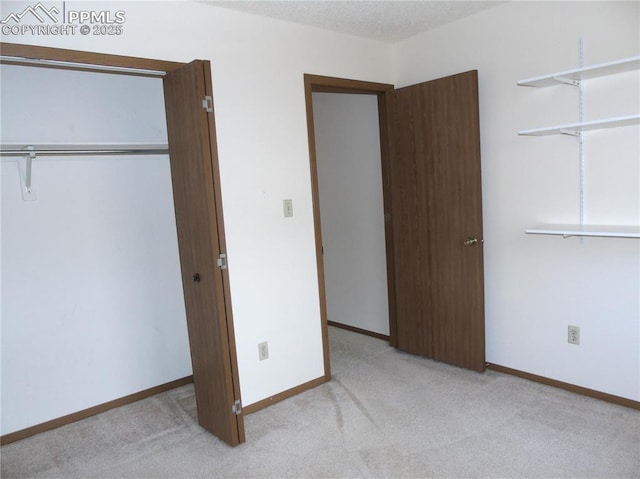 unfurnished bedroom featuring a closet, baseboards, and carpet floors