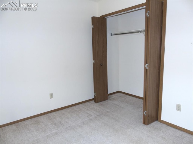 unfurnished bedroom featuring a closet, baseboards, and carpet