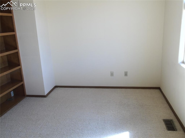 spare room featuring visible vents, baseboards, and carpet