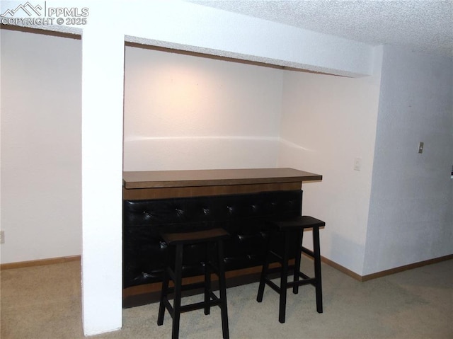 carpeted office space featuring baseboards and a textured ceiling