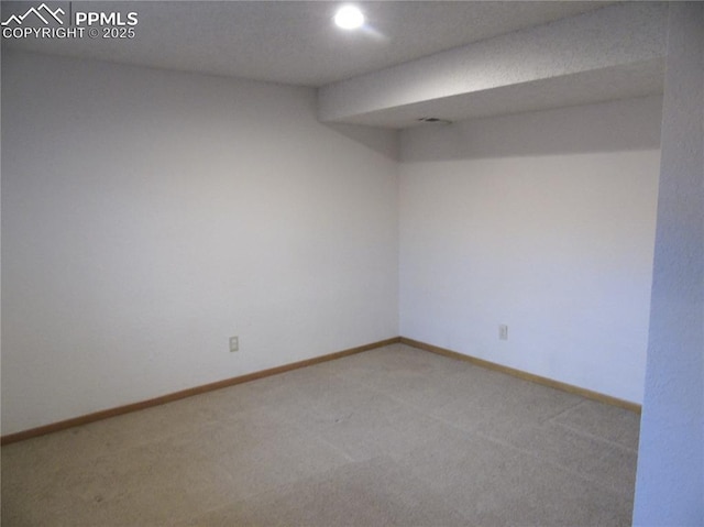 unfurnished room featuring baseboards and light carpet