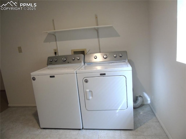 clothes washing area featuring light tile patterned floors, baseboards, independent washer and dryer, and laundry area