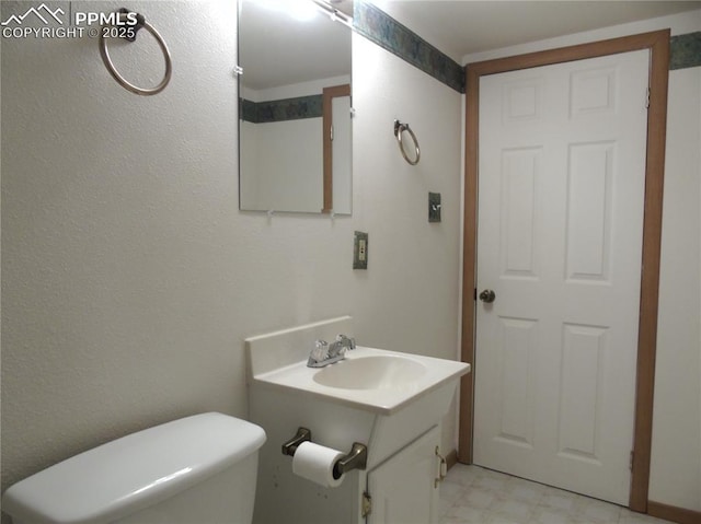 bathroom featuring tile patterned floors, toilet, and vanity