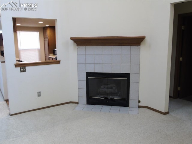 room details featuring baseboards, carpet, and a tile fireplace