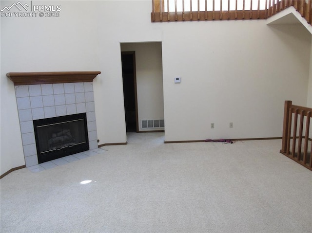 unfurnished living room featuring visible vents, carpet flooring, and a tile fireplace