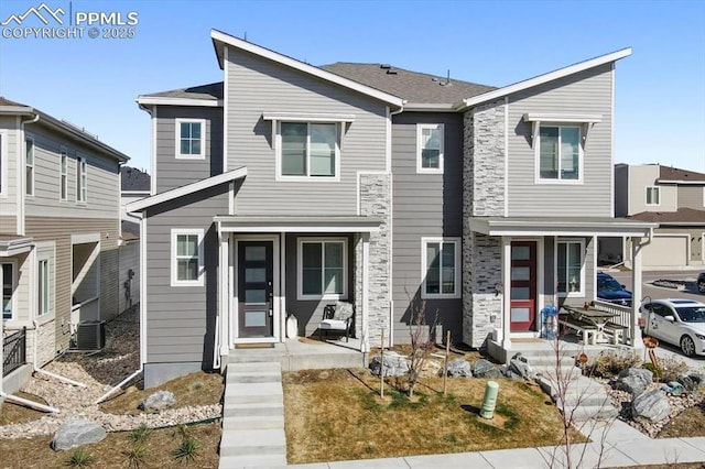 view of front of house featuring stone siding, covered porch, and central AC