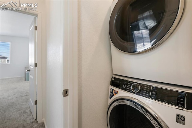 clothes washing area featuring stacked washer and dryer, carpet flooring, and laundry area