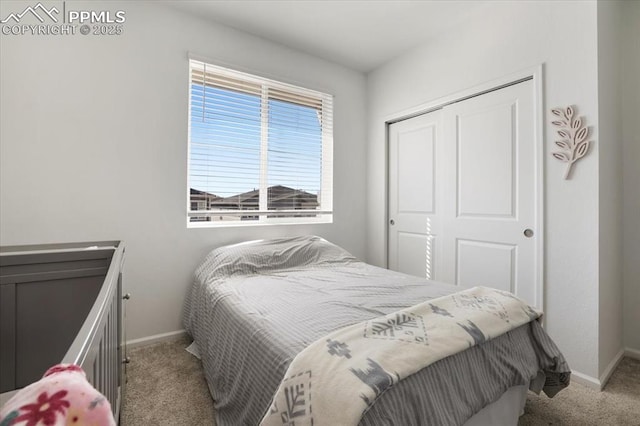 carpeted bedroom with a closet and baseboards