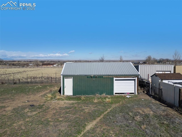 detached garage featuring fence and driveway