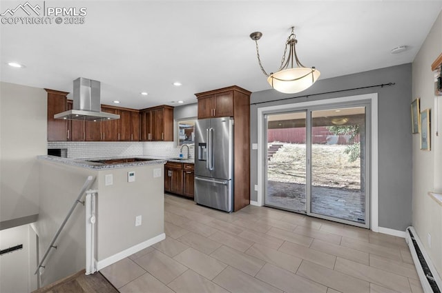 kitchen featuring a baseboard heating unit, decorative backsplash, island exhaust hood, high end fridge, and a sink