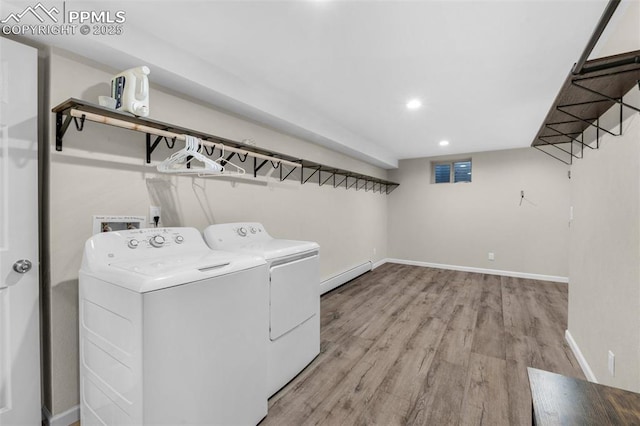 washroom with washer and clothes dryer, a baseboard heating unit, light wood finished floors, baseboards, and laundry area