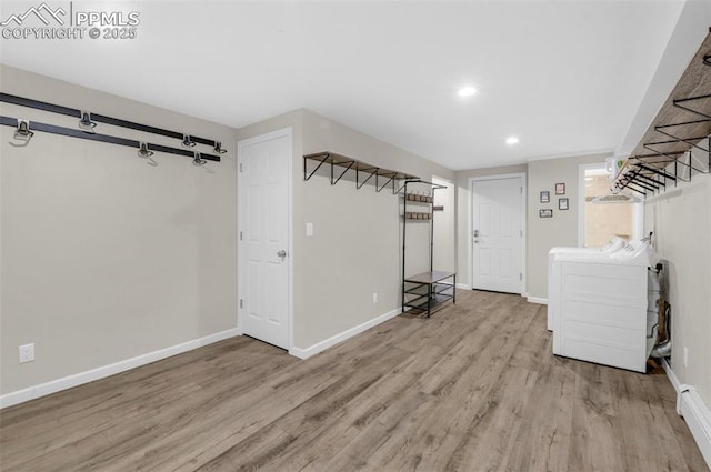 below grade area with independent washer and dryer, baseboards, and wood finished floors