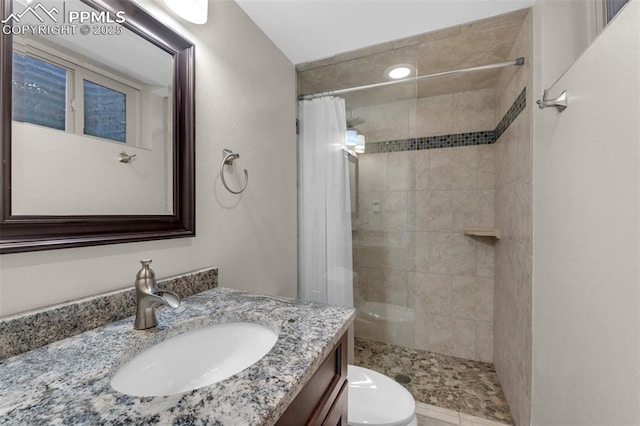 full bath with vanity, a shower stall, and toilet