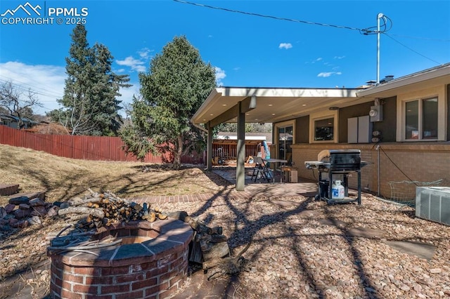 view of yard with a patio area, a fire pit, cooling unit, and fence