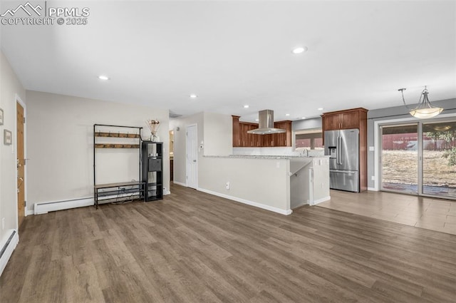 kitchen with wood finished floors, island exhaust hood, stainless steel fridge, and a baseboard radiator