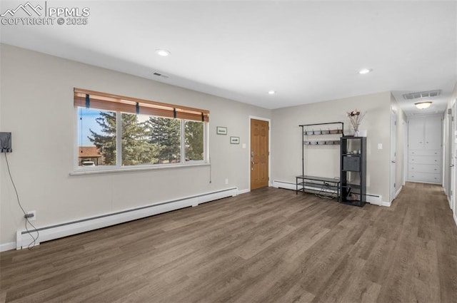 unfurnished living room featuring recessed lighting, visible vents, baseboard heating, and wood finished floors