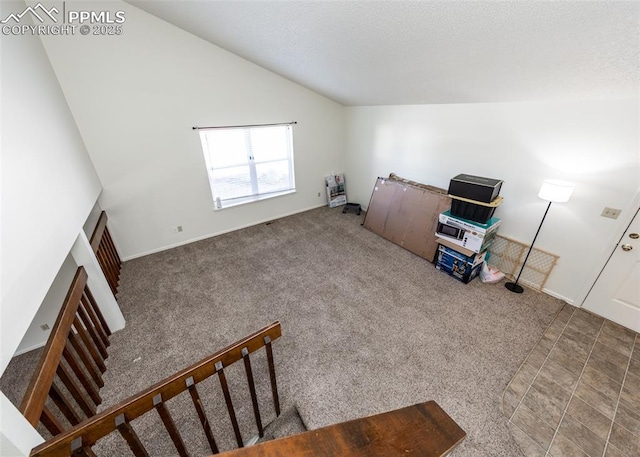 interior space with lofted ceiling, stairway, a textured ceiling, and baseboards