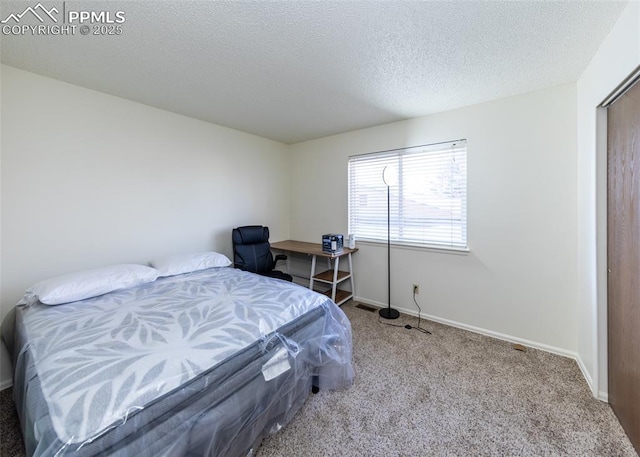 carpeted bedroom featuring a textured ceiling and baseboards