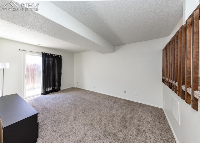 carpeted empty room with visible vents, a textured ceiling, and baseboards