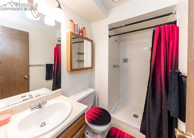 bathroom featuring tiled shower, vanity, and toilet