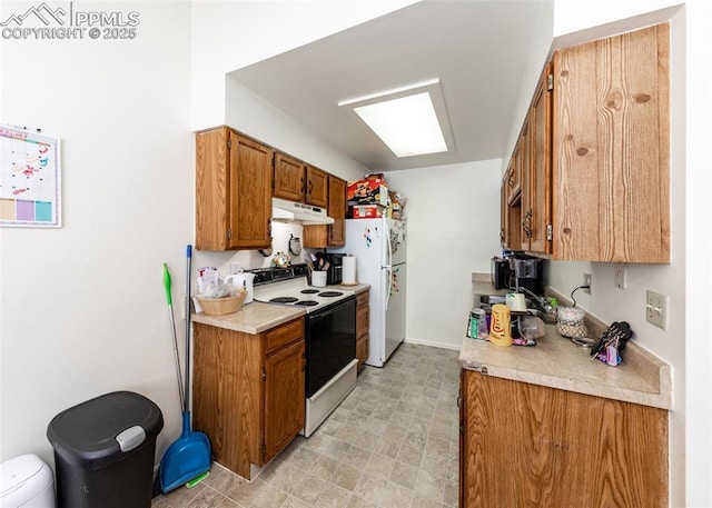 997 Magnolia St, Colorado Springs, CO 80907 - kitchen featuring under cabinet range hood, brown cabinetry, electric range oven, and freestanding refrigerator