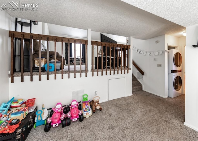 997 Magnolia St, Colorado Springs, CO 80907 - recreation room with visible vents, a textured ceiling, stacked washing maching and dryer, and carpet