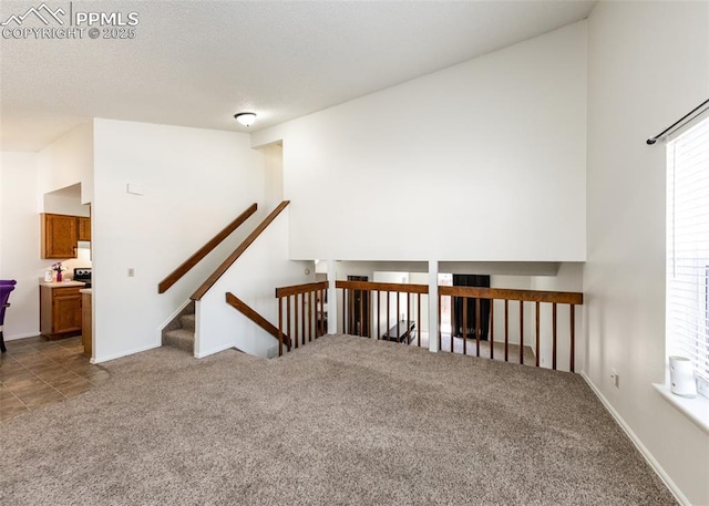 carpeted empty room featuring a textured ceiling