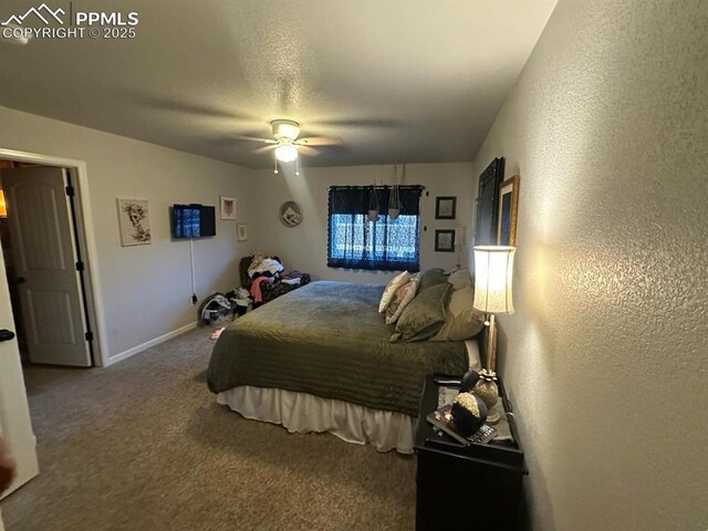 bedroom featuring baseboards, carpet floors, ceiling fan, a textured ceiling, and a textured wall