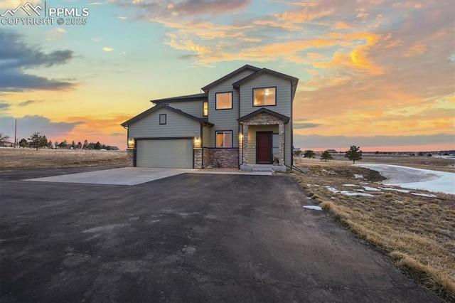 view of front of house with stone siding, concrete driveway, and an attached garage