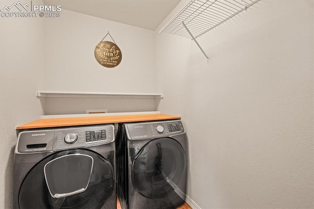 laundry room with laundry area, washing machine and dryer, and baseboards