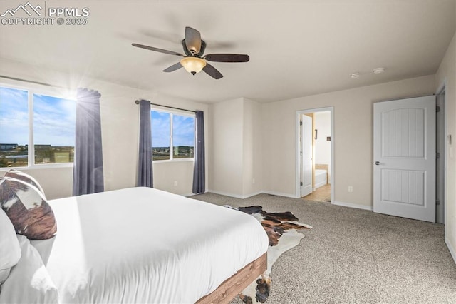 carpeted bedroom featuring ensuite bathroom, ceiling fan, and baseboards