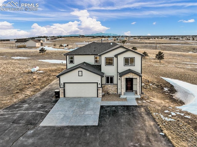 traditional home featuring a garage, stone siding, a shingled roof, and concrete driveway