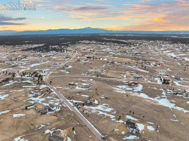 aerial view at dusk featuring a mountain view