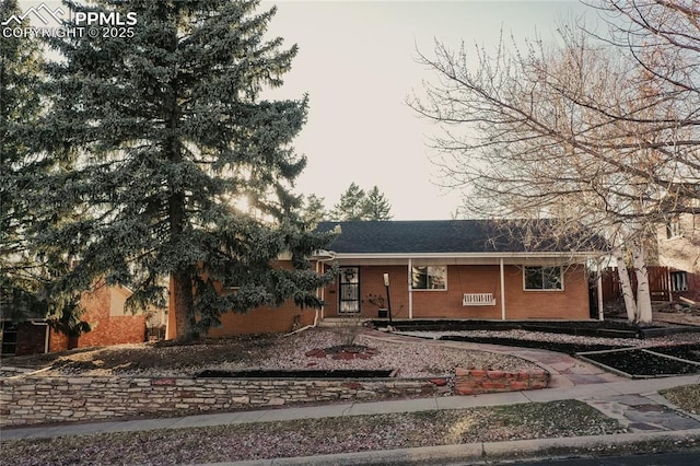 ranch-style house featuring brick siding