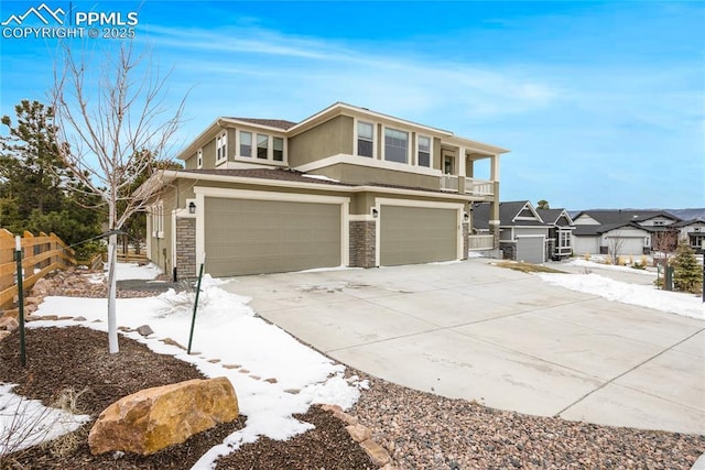 prairie-style house with stucco siding, fence, a garage, stone siding, and driveway