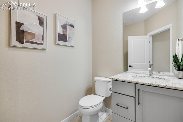 half bath with baseboards, vanity, toilet, and tile patterned floors