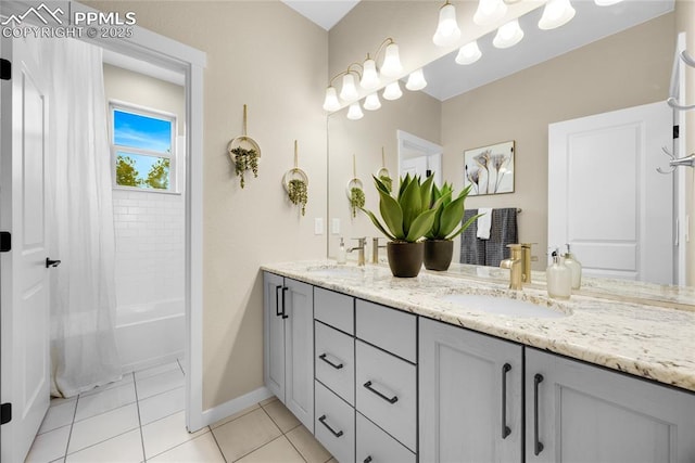 full bathroom featuring double vanity, a sink, baseboards, and tile patterned floors