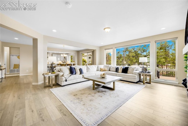 living room with light wood-style floors, a notable chandelier, and recessed lighting